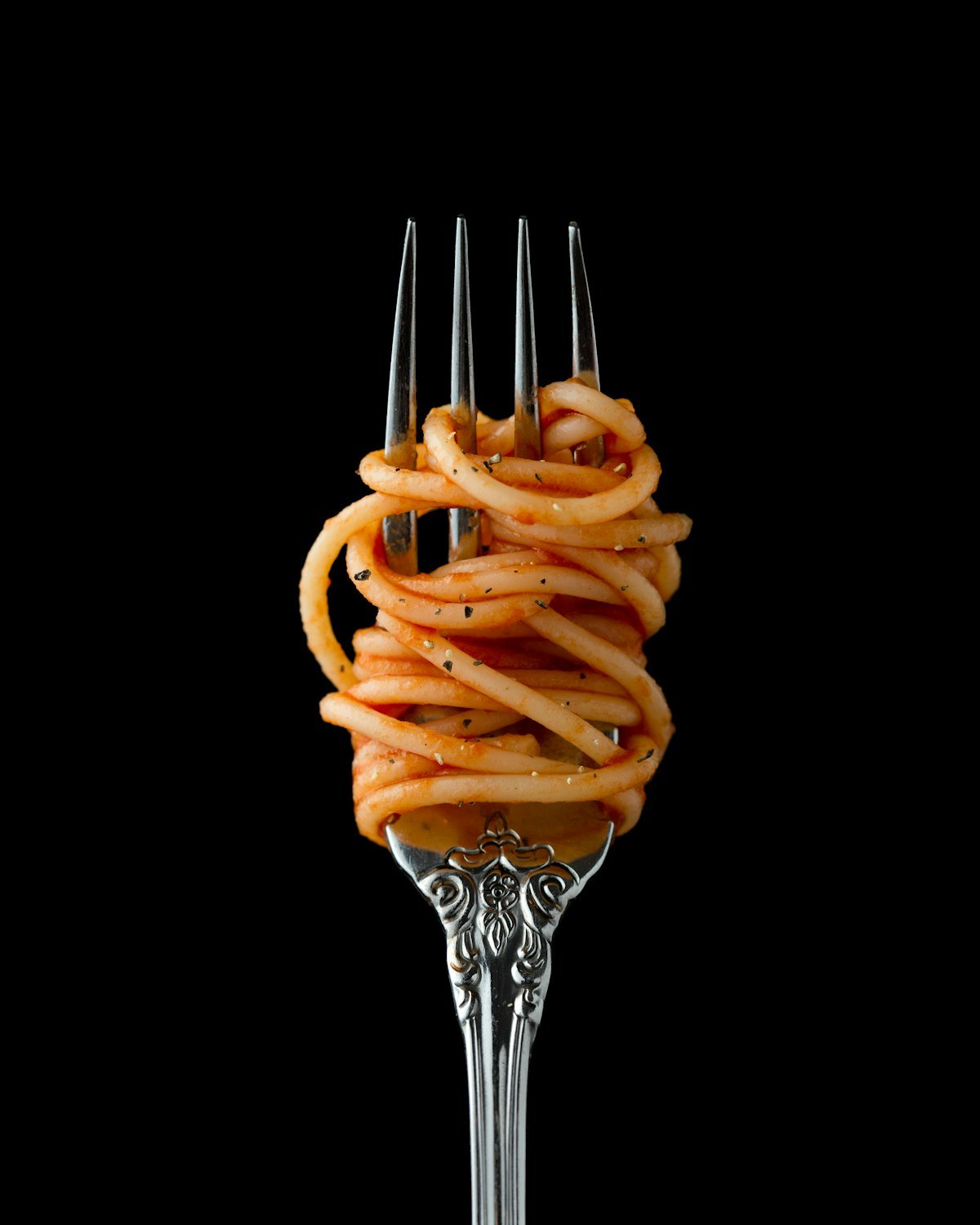 Spaghetti enroulés autour d’une fourchette sur fond noir